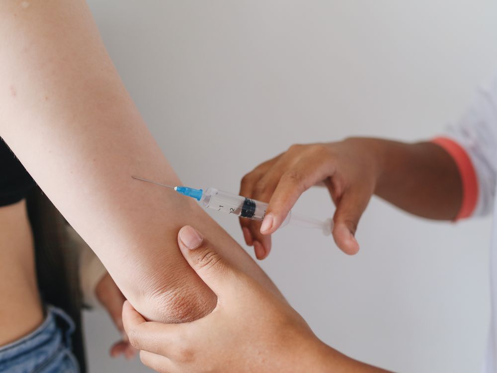A vaccine being administered into an upper arm